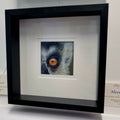 Close-up coloured pencil drawing of a lemur's eye representing alertness, presented in a deep black frame with a generous double mount.
